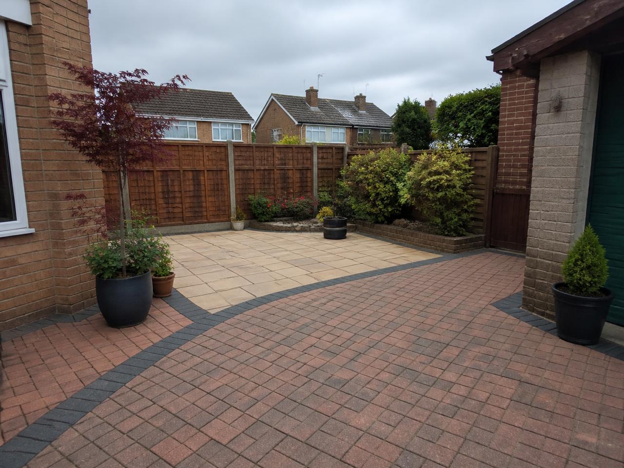 A clean, weed-free block-paved patio and driveway in a British garden